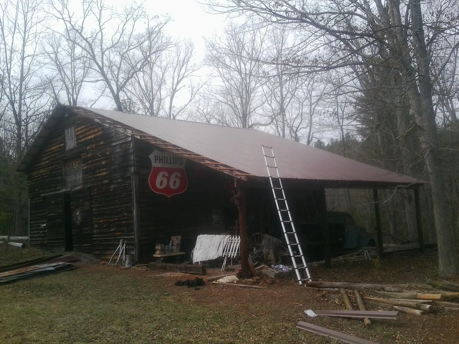 New metal roof on an open sided timber barn with a vintage sign in Phelan