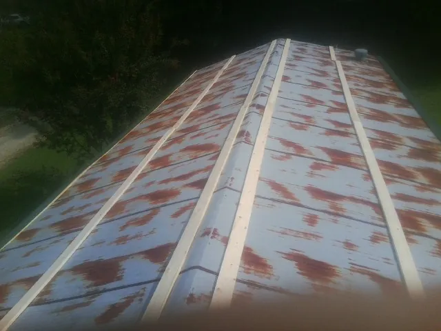 Rusted metal roof panels with new wood purlins before replacement — Storm Damage Roof Repair in Phelan by Roofing Brothers