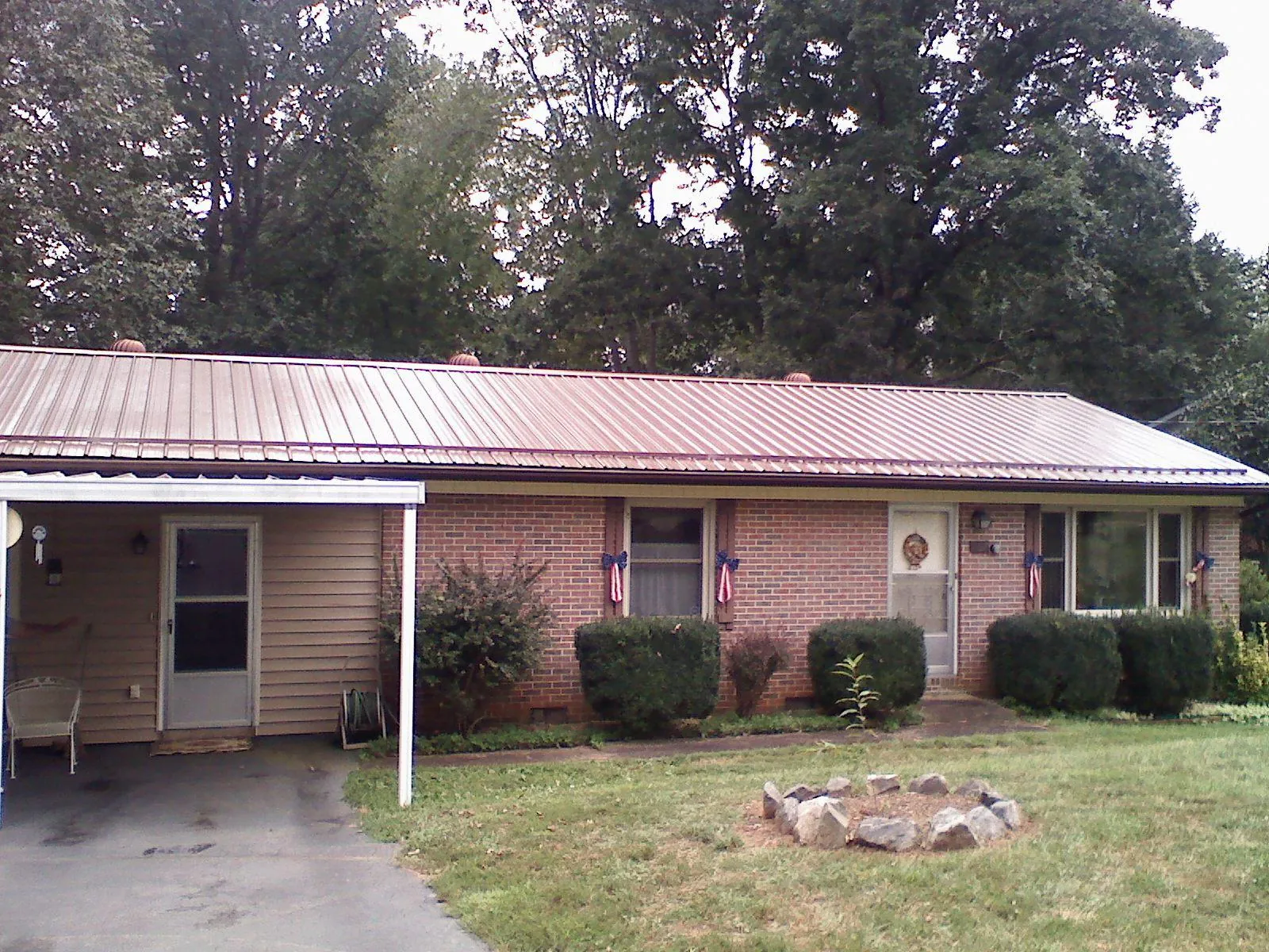 Bronze metal roof and carport on a brick ranch home — Roof Repair work by our crew in Phelan